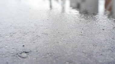 Arka plan gökyüzü yansıması ile ıslak asfalt ve su birikintisi. Çerçeve. Gökyüzü ve binalar yansıması ile ıslak yol yüzeyi için yakın çekim.