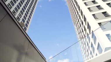 Modern ofis binaları mavi gökyüzü arka plan üzerinde bir grup bakarak. Çerçeve. Cam şehir binaları sırasında güneşli bir gün, düşük açılı görünüş.