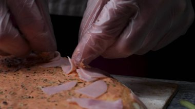 Pişirme pizza ağır çekim. Çerçeve. Peynirli pizza yapımı, domates salçası, sosis ve hardal. Aşçı iş. Aşçı, peynir ve domates salça ile adet sosis ve pizza düzenler. Tam