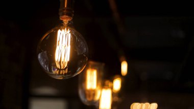 Vintage tarzı Işık Ampüller asmak ve bir oturma odası dekore edilmiştir. Retro lüks ışık lamba dekor parlayan. Edison ışığı. Ahşap duvar, alan derinliği kamera üzerinde arka plan asmak