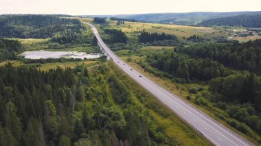 Havadan görünümü üzerinde dağ yol orman manzara gidiyor. Küçük. Araba ve orman arka plan sürüş ile dağ yolu ile güzel manzara. Dağlarda günbatımı.