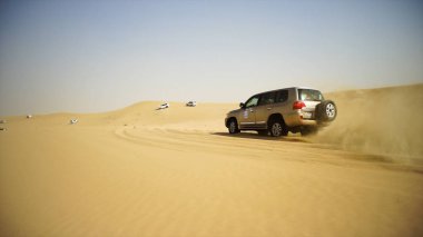 SUV gezi çölde turistler için. Hisse senedi. Bir grup insan kapalı yol araba Vietnam çölde safari sırasında sürüş. Dune kum üzerinde eğleniyor arkadaş topluluğu. Otantik macera kavramı
