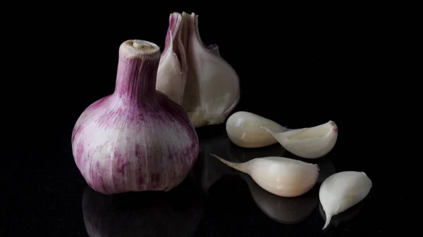 Onions and garlic over black background. Still-life of onions and falling garlic on black background