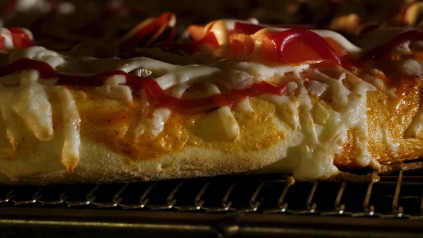 The cook puts pizza bread into burning stove. Frame. Pizza making closeup with green olives and peppers and cheese in the oven — Stock Photo, Image