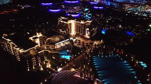 Vue aérienne sur le territoire hôtelier de luxe la nuit. Vidéo. Vue de nuit du territoire intérieur éclairé du complexe hôtelier avec sentiers pédestres, palmiers et piscine. Hôtels de villégiature tropicale vue de dessus de nuit . — Photo