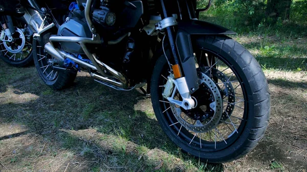 Primer plano de una rueda de motocicleta, fondo del bosque. Clip. Primer plano de las pruebas de ruedas de la motocicleta mientras que la competencia en el parque natural — Foto de Stock