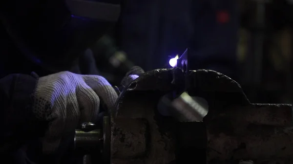 Soldadura de hierro con luz brillante y humo en la fabricación. Clip. El hombre trabajador industrial en la soldadura de fábrica de cerca por arco — Foto de Stock