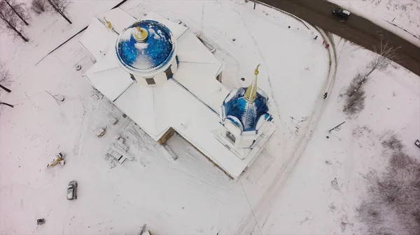 Zonsondergang winter bos in de buurt van de rivier, luchtfoto van de oude kerk, luchtfoto. Clip. Luchtfoto op oude witte christelijke kerk in de buurt van de rivier met blauwe dak — Stockfoto