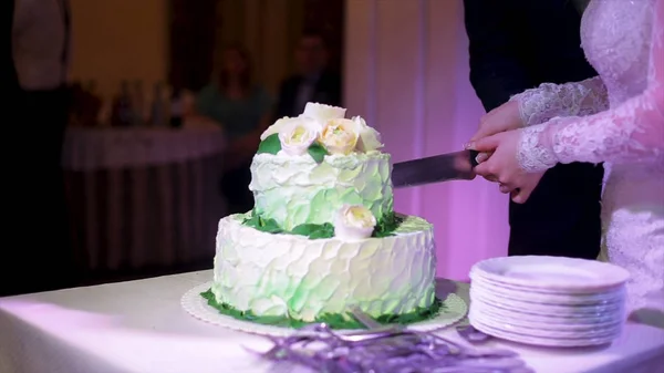 Brides pokroić tort weselny. Panna młoda i pan młody jest cięcie ich tort weselny. Rękach panny młodej i pana młodego Wytnij plasterek tort weselny — Zdjęcie stockowe