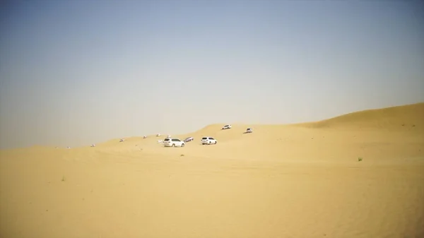 Havadan görünümü ile Dubai şehir silüetinin ya da cityscape gün batımında Arap Çölü'nde Suv ile Off-road maceraya. Çöl SUV ile turne. Offroad Suv çölde at binme. 4 çekişli Suv üzerinde sürüş — Stok fotoğraf