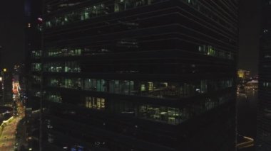 Singapur - 25 Eylül 2018: Windows insanlar geceleri büyük şehirde bir ofis iç çalışma ile. Vurdu. Gece büyük şehir hayatı, güzel cam cephe gökdelen için Kapat