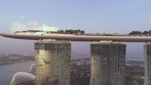 Singapur - 25 de septiembre de 2018: Vista lateral del hotel Marina Bay Sands con increíble góndola en la azotea. Le dispararon. Marina Bay Arenas en el cielo y el fondo del río, Singapur . — Vídeo de stock