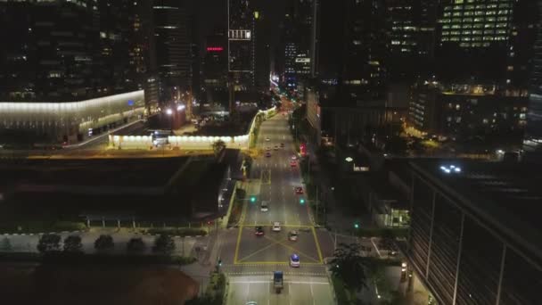 Singapura - 25 de setembro de 2018: Arquitetura noturna, arranha-céus com fachada de vidro e estrada quase vazia. Atingido. Edifícios modernos em distrito de negócios, tráfego da tarde em uma rua . — Vídeo de Stock