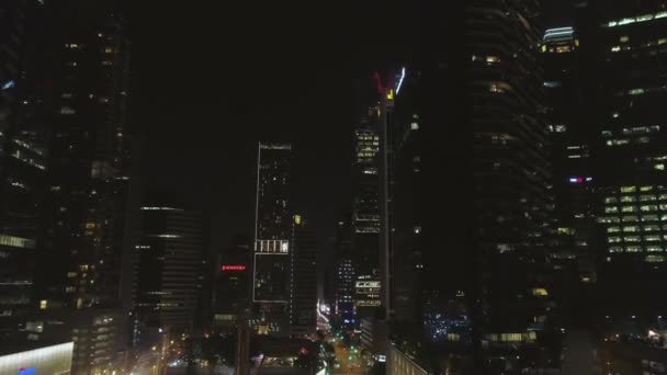 Singapur - 25 de septiembre de 2018: Arquitectura nocturna, rascacielos con fachada de cristal y carretera casi vacía. Le dispararon. Edificios modernos en el distrito de negocios, tráfico nocturno en una calle . — Vídeos de Stock