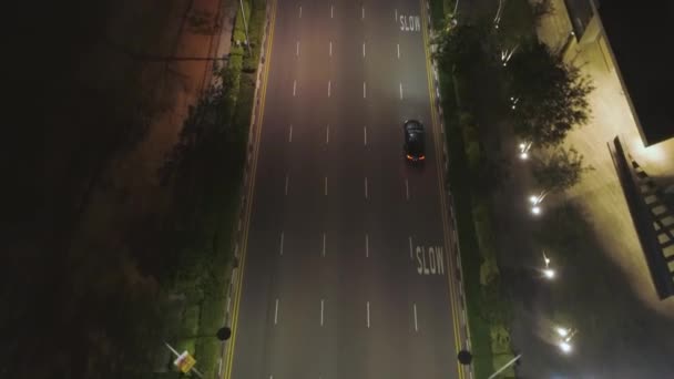 Top view of street with cars and modern buildings in big Chinese city at night. Shot. Night aerial view of city center with its road, moving cars, lights of skyscrapers, night life concept. — Stock Video