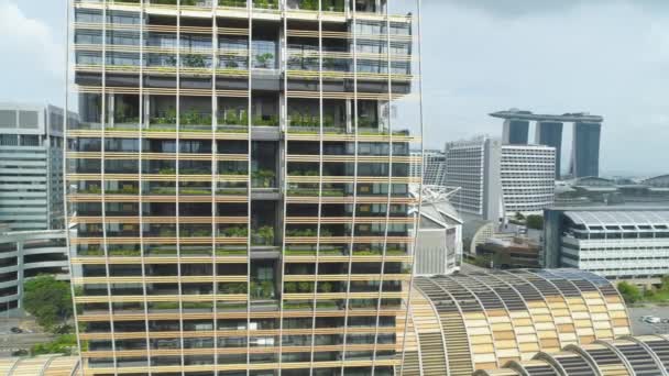 Singapore - 25 September 2018: närbild av Visa för vertikala skog byggnad i centrum av staden, naturen sparar konceptet. Skott. Modern, ovanligt utformad byggnad med många träd på balkongerna — Stockvideo