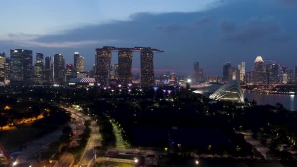 Singapur - 25 září 2018: panoráma Singapuru a řeka v noci s slavný Marina Bay sands, Ruské kolo a další městské budovy. Střela. Krajina ze Singapuru kancelářské budovy Marina a okolí — Stock video