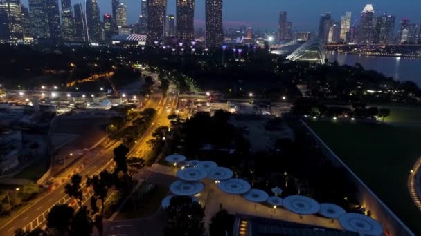 Singapur - 25 de septiembre de 2018: horizonte y río de Singapur por la noche con famosas arenas de Marina Bay, noria y otros edificios de la ciudad. Le dispararon. Edificio de negocios Paisaje de Singapur alrededor de Marina — Vídeos de Stock