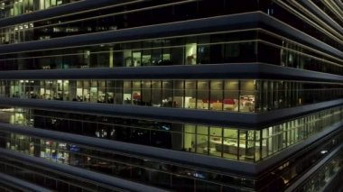 Dış köşe ışıklı pencereler ve içinde insanlar modern ofis için kapatın. Gece, ışıklı windows arka plan şehir ofis binası köşede, hava.