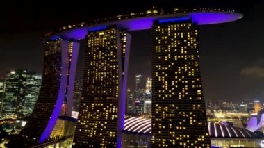 Marina Bay Sands hotel güzel mor lazer ve aydınlatma göstermek geceleri ışıklı Singapur. Mor parlak ile gece çarpıcı Marina Bay sands doğru hareket.