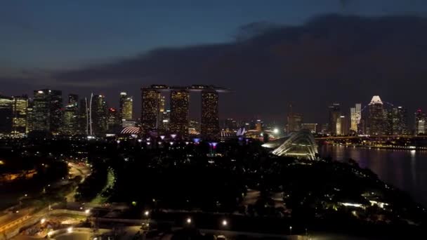 Singapore di notte panorama urbano con ruota panoramica e Marina Bay Sand, vita notturna Singapore. Gli hanno sparato. Singapore, città che non dorme mai, con la sua luminosa illuminazione notturna . — Video Stock