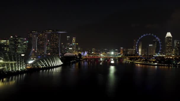 Singapore - 25 September 2018: Singapore by night cityscape panorama with Ferris wheel and Marina Bay Sand, night Singapore life. Shot. Singapore, city that never sleeps, with its bright night — Stock Video