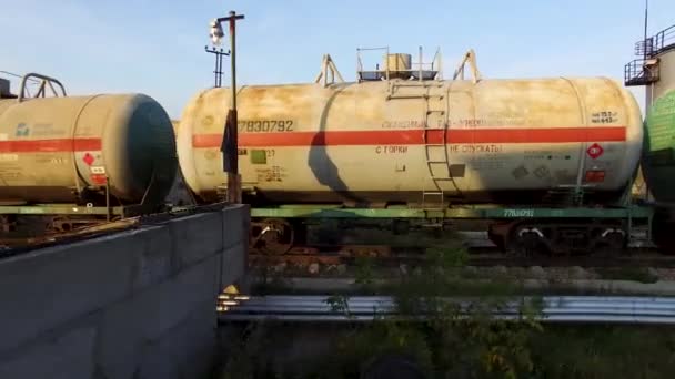 Petrol ve yakıt taşıma ile demiryolu tanklarla kümesi. Hisse senedi. Sarnıç petrol mavi gökyüzü ve yeşil alan arka plan üzerinde raylar üzerinde. — Stok video