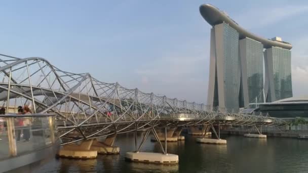 Singapur - 28 Haziran 2018: Beton kaplı paslanmaz Marina Bay Sands Hotel köprüye bulutlu bir günde Singapur'da. Singapur şehir gündüz. Helix Köprüsü ve Marina Bay kuma — Stok video