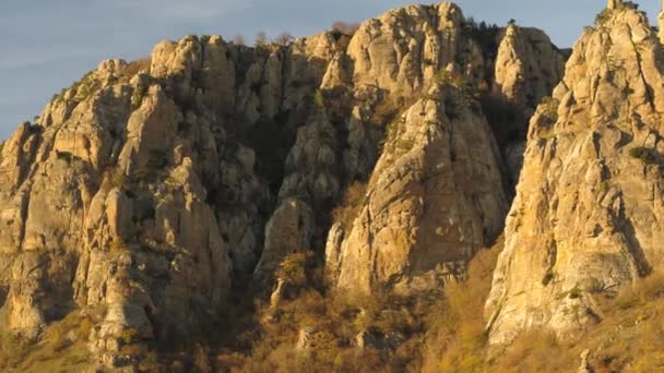 Vista aérea de vuelo en la hermosa y enorme roca de montaña al atardecer. Le dispararon. Piedras y rocas sobre fondo montañoso con luz solar — Vídeos de Stock