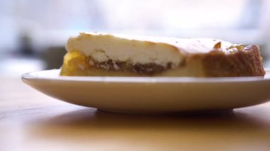 Pasta ve çay kahve dükkanı penceresinde tarafından masada. Seçici odak. Ahşap masa üzerinde kahve ve frambuazlı çörek. Kupa ile güneşli pencere arkasında ışık ruj.