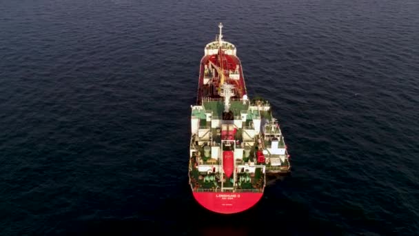 Grote container schip op zee - Top-down luchtfoto beeldmateriaal. Luchtfoto beelden van een vrachtschip op de open zee met andere schip en de bergen op de achtergrond — Stockvideo