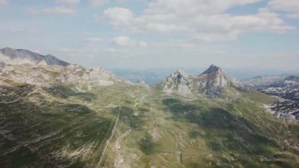 Ovanifrån över bergen. Lager. Solig dag med moln i bergen. Spännande landskap av berg och klippor. Berget dalen med klippor — Stockvideo