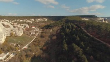 Havadan görünümü kayalık uçurum, orman ve mavi gökyüzü karşı küçük bir köy. Vurdu. Erken sonbahar manzara