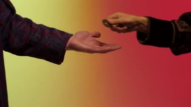 Doğu adam el bir bronz sikke öder ve kurutulmuş yaprak baharat haddelenmiş kağıt parlak arka plan üzerinde Doğu bazar kavramı izole satıcı elinden alır. Hisse senedi. Adam bronz sikke Baharatlar için ödeme.