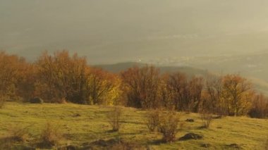 Günbatımı gökyüzü arka plan üzerinde panoramik manzaralı sonbahar vadinin dik bir gür yamaç üzerinden. Vurdu. Küçük bir villadge ve günbatımı Altın ışık alan muhteşem dağ manzarasına.