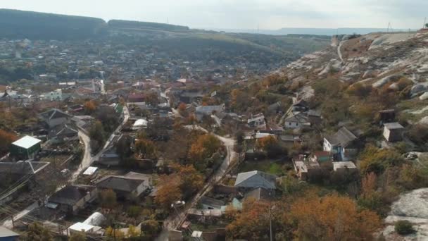 Město nedaleko útesů proti modré obloze. Střela. Letecký pohled — Stock video