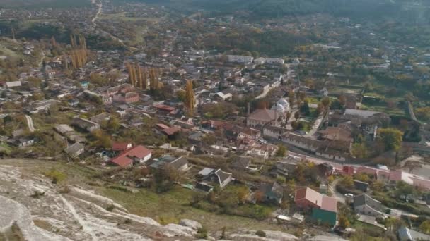 Krásná krajina město ležící mezi kopci v nížinách. Střela. Výhled z vrcholu kopce — Stock video