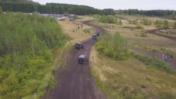 Moscova, Rusia - septembrie 2018: Curse extreme de mașini off-road. Clip. Vedere de top a cursei off-road. Evenimentul sezonului în Motorsport. Cursă murdară cu mulți spectatori și fani sunt pe drum în pădure în nori — Videoclip de stoc