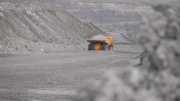 ダンプ ボディー トラックは、採石場で鉱石と読み込まれた道路に沿って移動します。背面図. — ストック動画