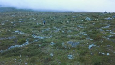 Onu dağlarda seyahat önünde siste uzanan yeşil ridge hayran maceraperest uçurumdaki. Arkadan görünüm. Yalnız bir ama dramatik dikiz üst tarafındaki adam kararlı bir