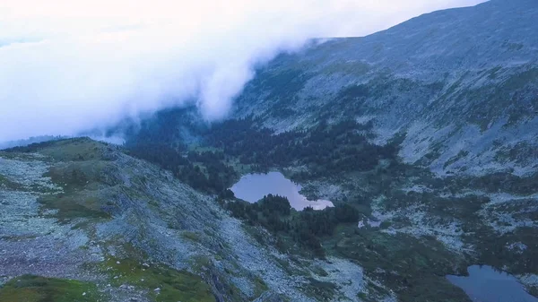 Mountain lake Flygfoto. Klipp. Vackra panorama av berglandskap med fantastisk damm. Flyger en quadcopter över en fjällsjö. — Stockfoto