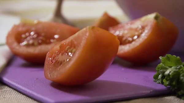 Tomatenscheiben fallen auf Schneidebrett, Super-Zeitlupe. Herabfallende Teile geschnittener Tomaten auf einem Holztisch — Stockfoto