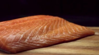 Siyah arka plan üzerine izole kahverengi ahşap kesme tahtası, taze, çiğ, kırmızı balık parçası. Ahşap Doğrama tahtası, pişirme ve sağlıklı diyet cocnept yalan güzel somon fileto