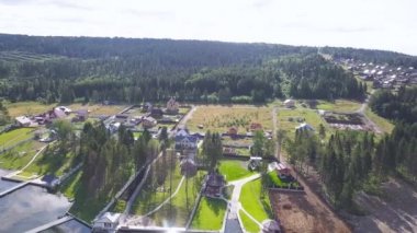 Üstten görünüm yazlık köyü göl. Küçük. Köy yoğun orman arka plan üzerinde göl kıyısında duran yeşil çim alanları ile modern evleri. Ülkede yaz sezonunda dinlenme