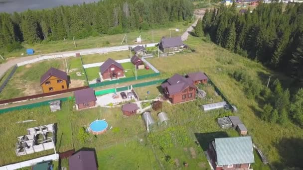 Vue de dessus de la route rurale et des banlieues. Clip. Village rural avec chalets en forêt. Vacances d'été dans le pays 