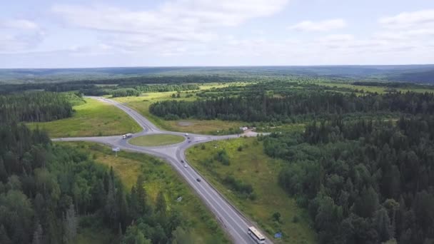 Bovenaanzicht van landelijke rotonde met verkeer. Clip. Mooi landschap van bos horizon en landelijke kruispunt van wegen in de ring. Regels van de weg bij rotonde — Stockvideo