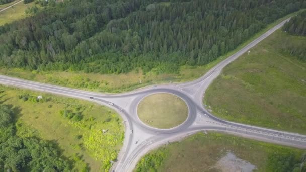 Vista dall'alto della tangenziale rurale con traffico. Clip. Vista panoramica di incrocio anulare con strade divergenti nella foresta. Orizzonte con lago blu e città costiera. Viaggi e riposo in estate — Video Stock