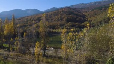 Sonbaharda Dağları'nın yansıması ile üstten görünüm küçük göl. Vurdu. Güzel manzara sonbahar güneşli gün gölde renkli dağların yansıması ile. Sonbahar doğanın güzelliği