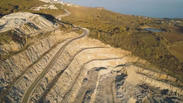 Panoramautsikt över stenbrottet. Skott. Ovanifrån av pittoreska quarry ligger på kustnära berg nära byn i skogen. Begreppet gruvdrift — Stockvideo