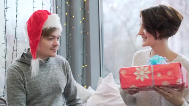 一个女孩送给他的男朋友他自己的圣诞礼物 这个人对他刚刚得到的惊喜感到满意 — 图库视频影像